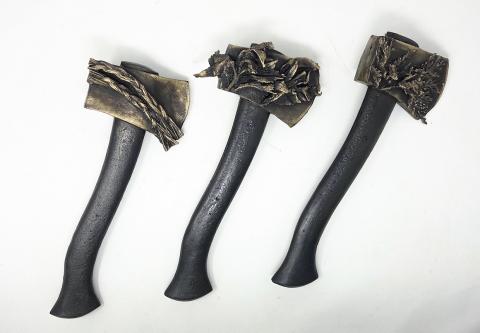 Three burnt, blackened matchsticks with cracked tips lying on a white background.